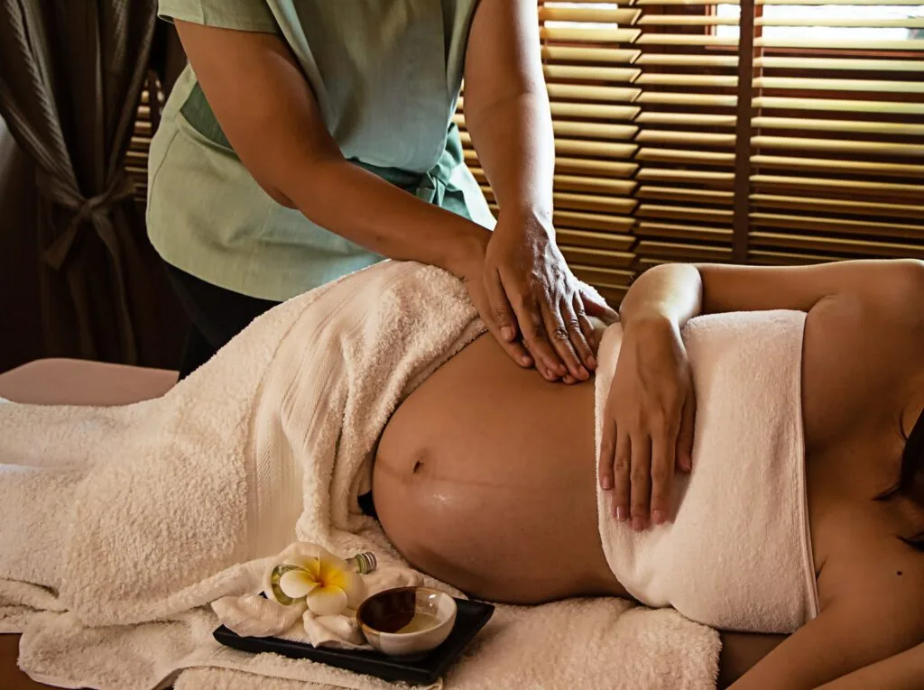 The therapiist hands massaging on belly of pregnant woman,for tr